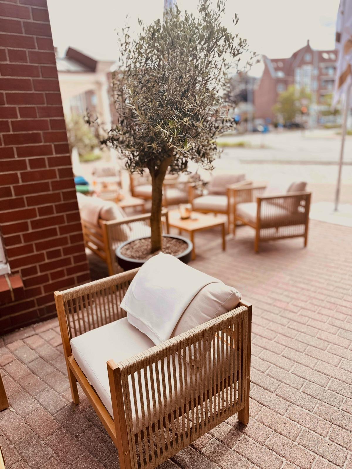 Heller Sitzbereich auf der Terrasse vor dem Hotel