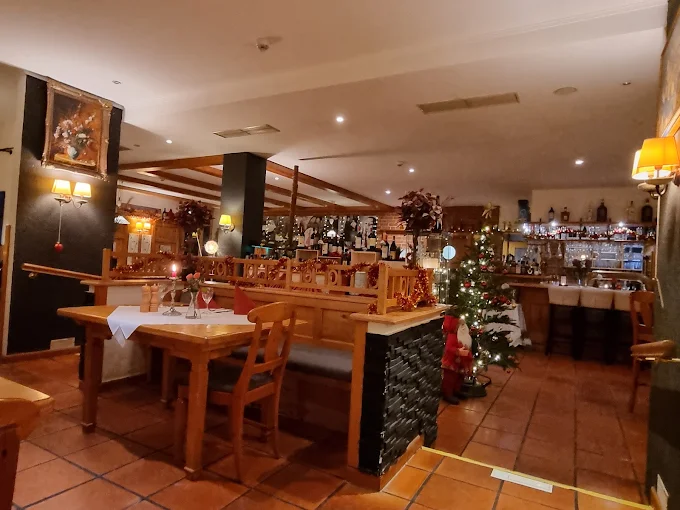 Warmer Gastraum am Abend mit Bar und Holzinterieur