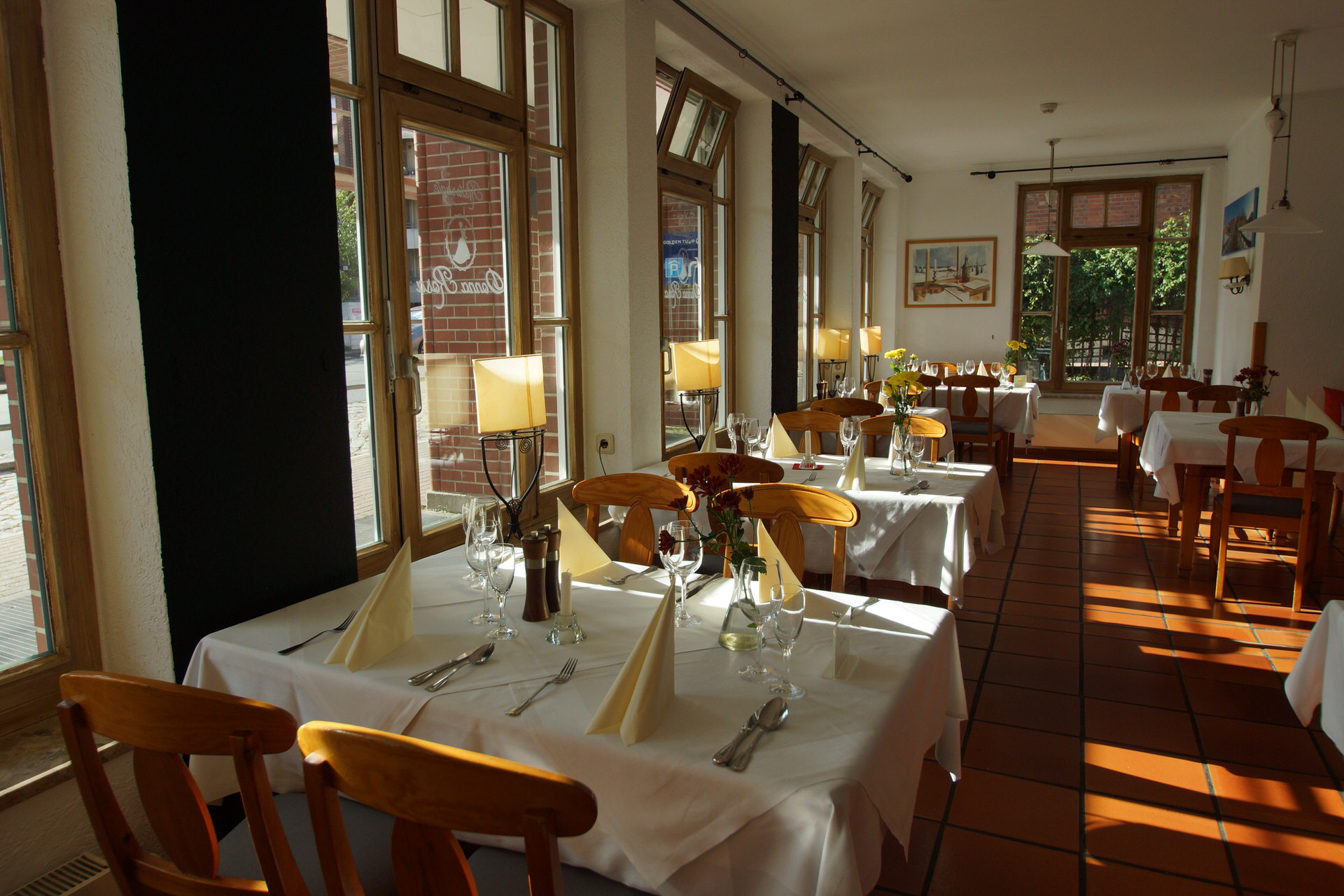 Heller Gastraum des Ristorante Donna Rosa mit gedeckten Tischen am Fenster